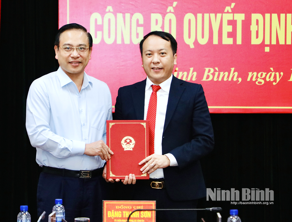 Đồng chí Đặng Thanh Sơn, Ủy viên Ban Thường vụ Tỉnh ủy, Phó Chủ tịch UBND tỉnh trao quyết định, tặng hoa chúc mừng tân Phó Giám đốc Sở Ngoại vụ Trần Quang Huy.