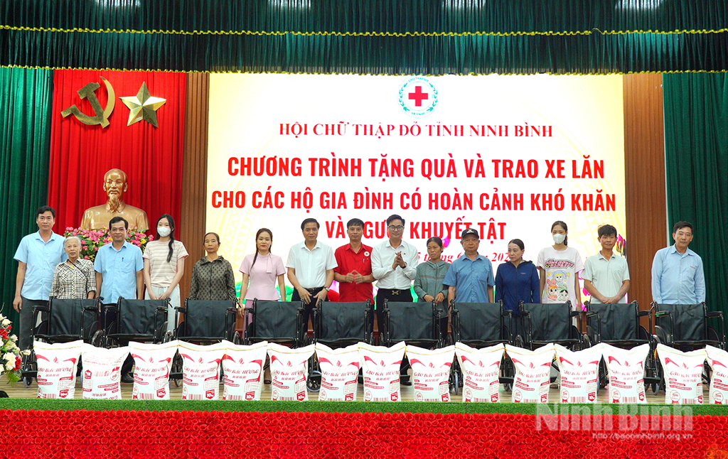 Các đại biểu trao tặng xe lăn cho đại diện người khuyết tật xã Ý Yên.