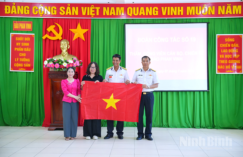 Đồng chí Phạm Kim Huệ, Phó Giám đốc Báo và phát thanh, truyền hình Ninh Bình trao tặng cờ cho đại diện đảo Phan Vinh
