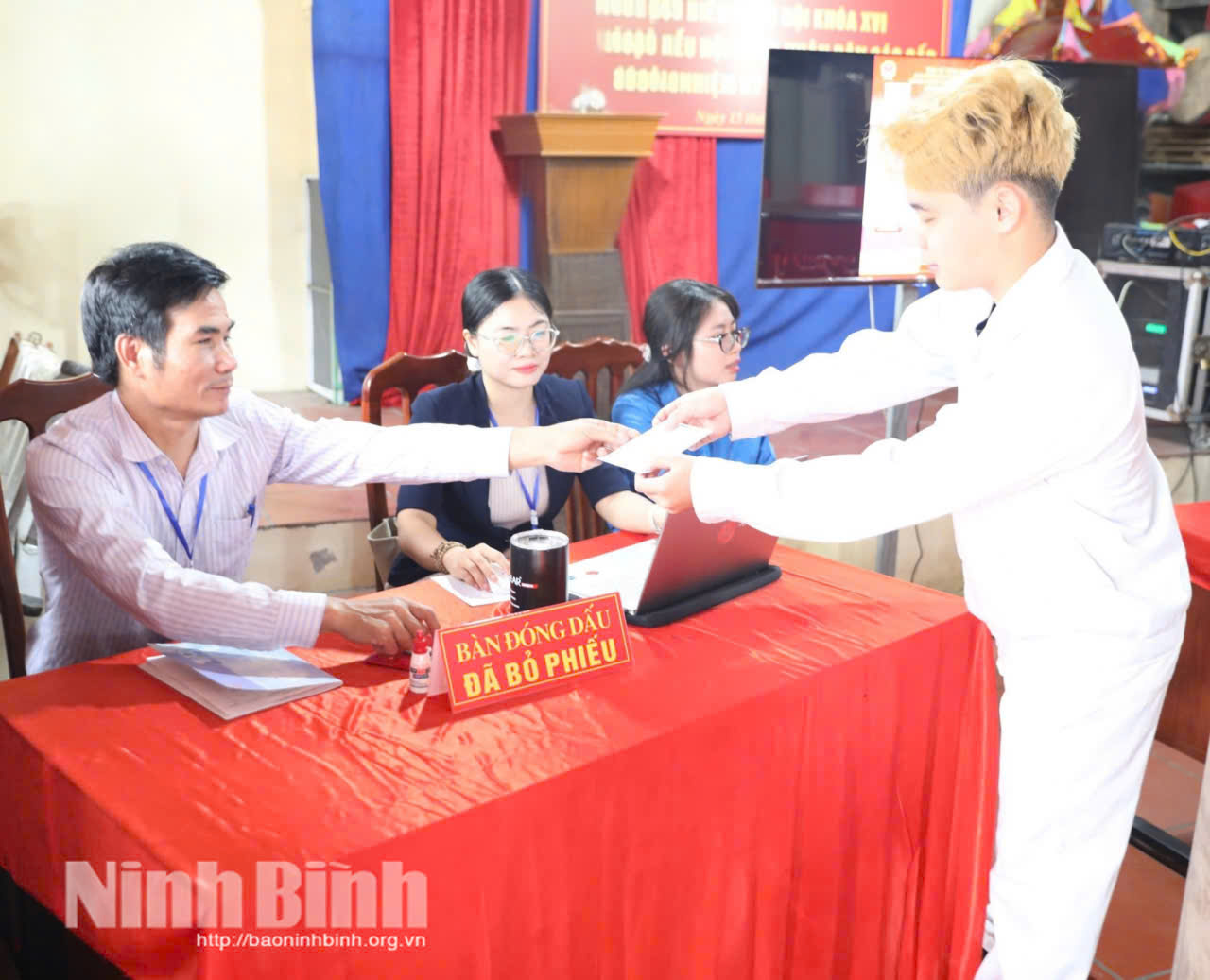 Cử tri Tổ dân phố Thần Nữ, phường Đồng Văn phấn khởi nhận phiếu xác nhận hoàn thành việc bỏ phiếu. Ảnh: Thuỳ Dung