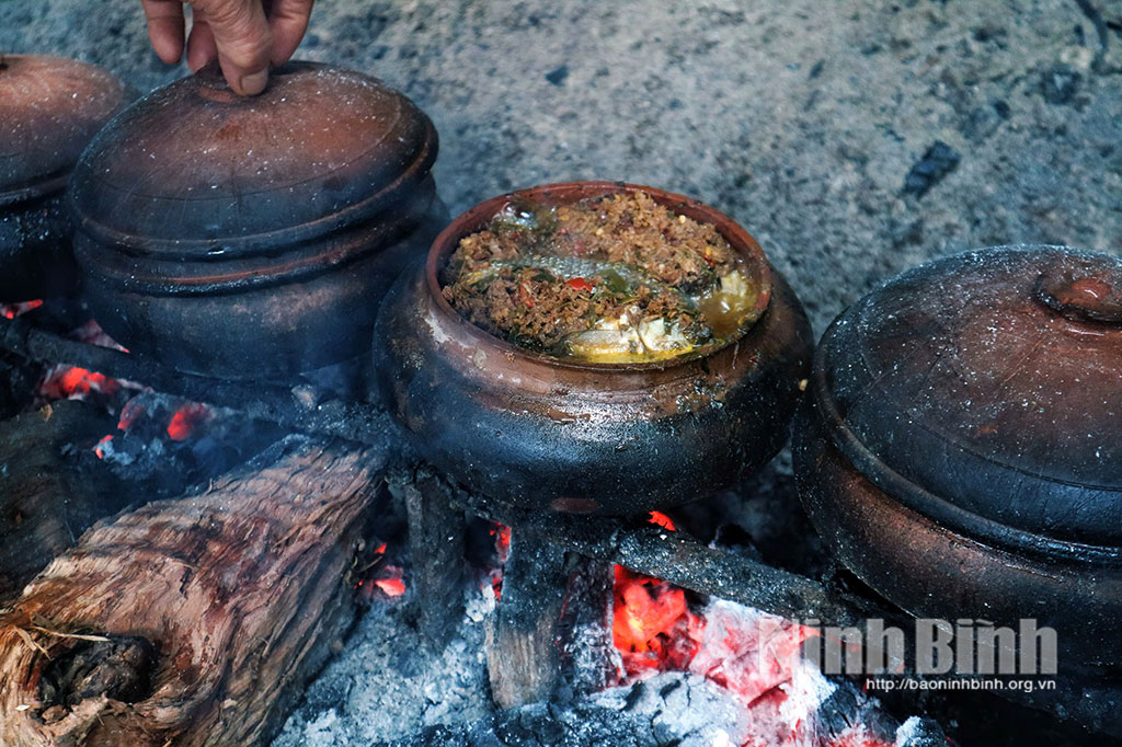 Cá kho chín vàng trên bếp lửa.