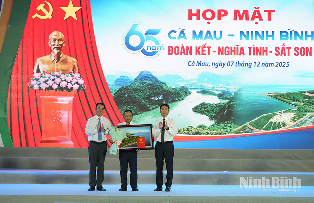 Đồng chí Chủ tịch UBND tỉnh Cà Mau Lữ Quang Ngời và đồng chí Trần Song Tùng, Ủy viên Ban Thường vụ Tỉnh ủy, Phó Chủ tịch Thường trực UBND tỉnh Ninh Bình trao tặng vật phẩm lưu niệm cho đại diện Ban Liên lạc đồng hương Ninh Bình tại tỉnh Cà Mau.