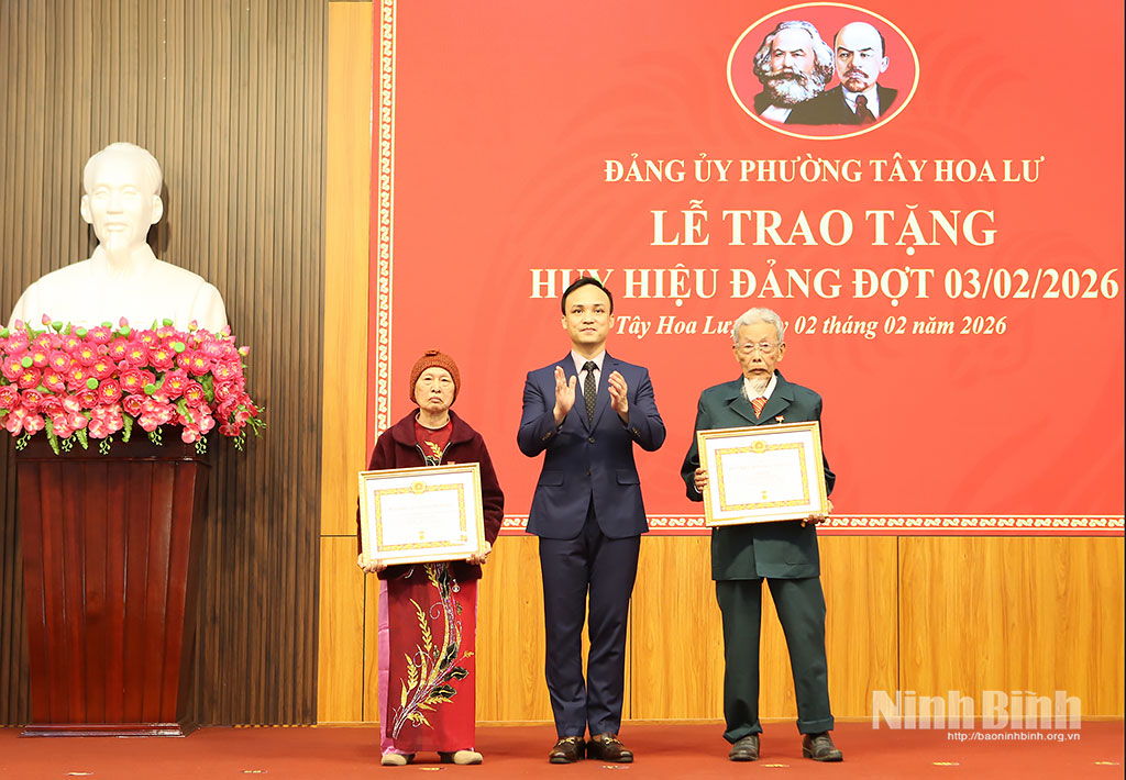 Đồng chí Cao Trường Sơn, Tỉnh ủy viên, Bí thư Đảng ủy phường Tây Hoa Lư trao tặng Huy hiệu 65 năm tuổi Đảng cho các đảng viên. Ảnh: Mạnh Hùng