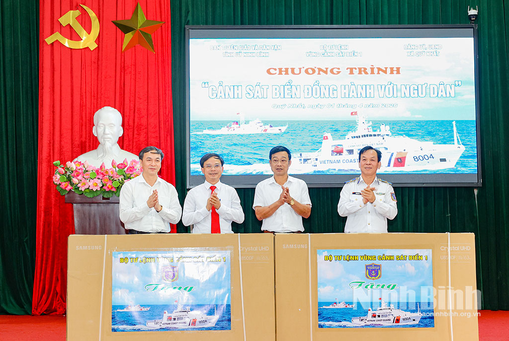 Thiếu tướng Trần Văn Thơ, Tư lệnh Vùng Cảnh sát biển 1 tặng quà lưu niệm 2 xã Quỹ Nhất và Rạng Đông. Ảnh: Viết Dư