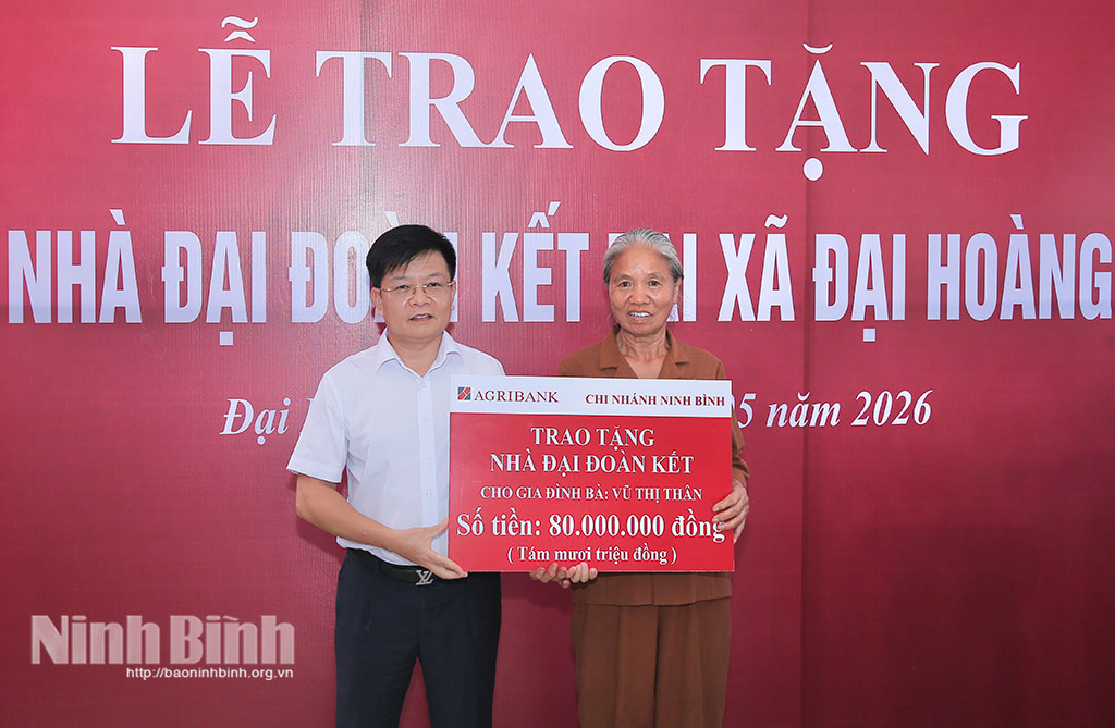 Lãnh đạo Agribank Chi nhánh tỉnh Ninh Bình trao biển hỗ trợ tiền cho gia đình bà Vũ Thị Thân.