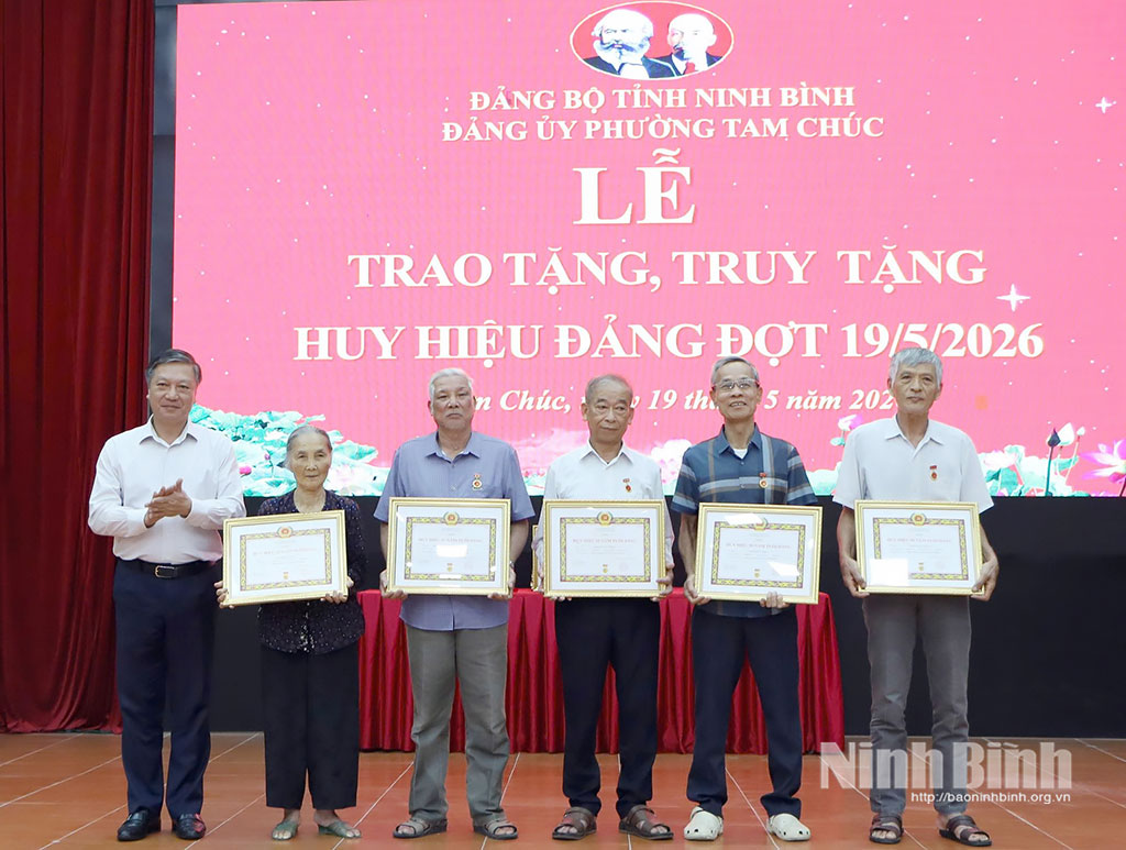Đồng chí Đinh Việt Dũng, Ủy viên Ban Thường vụ Tỉnh ủy, Trưởng Ban Tổ chức Tỉnh ủy trao Huy hiệu Đảng cho các đảng viên phường Tam Chúc. Ảnh: Nguyễn Oanh