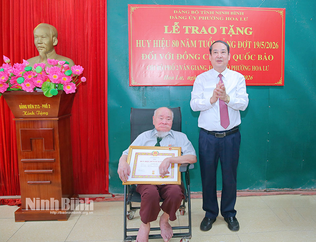 Đồng chí Mai Văn Tuất, Phó Bí thư Tỉnh uỷ, Trưởng Đoàn đại biểu Quốc hội tỉnh trao Huy hiệu 80 năm tuổi Đảng cho đồng chí An Quốc Bảo.