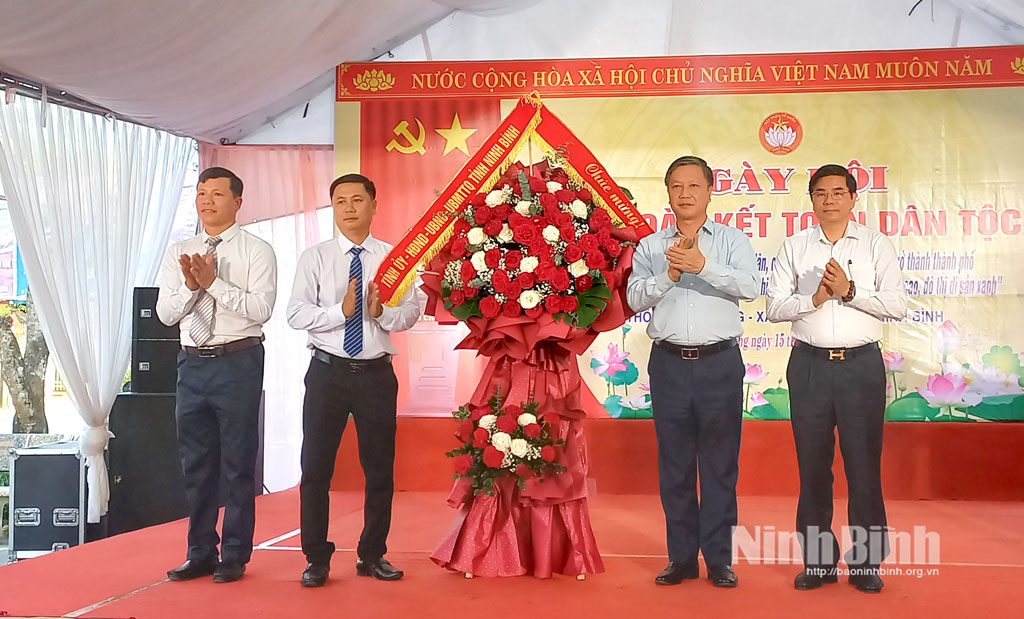 Đồng chí Đinh Việt Dũng, Ủy viên Ban Thường vụ Tỉnh ủy, Trưởng Ban Tổ chức Tỉnh ủy tặng hoa chúc mừng Ngày hội Đại đoàn kết toàn dân tộc tại thôn Tập Thượng, xã Bình Mỹ.