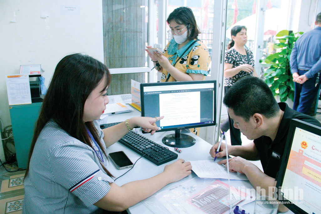 Cán bộ phường Nam Định hướng dẫn người dân tra cứu dịch vụ công trực tuyến trên bảng điện tử.