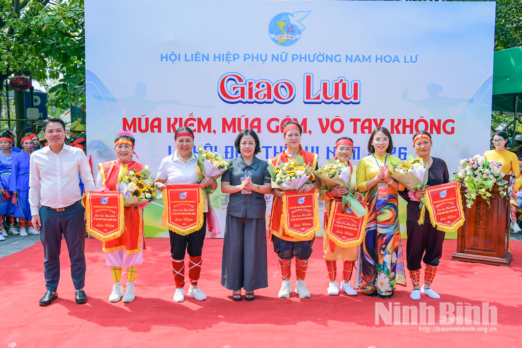 Đại diện lãnh đạo phường Nam Hoa Lư trao cờ lưu niệm cho các đội tham gia giao lưu "Múa kiếm, múa găm, võ tay không".