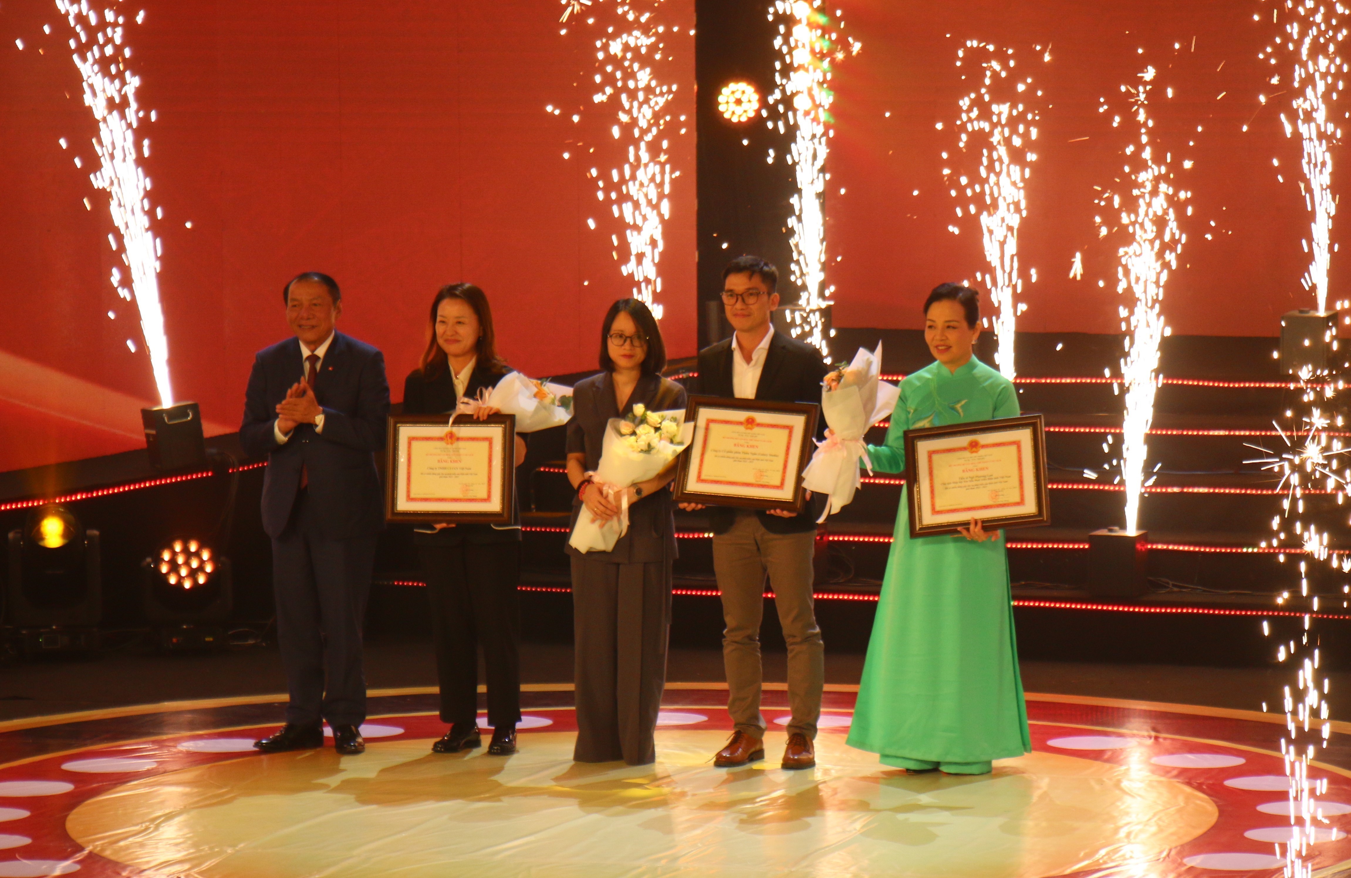 Bộ trưởng Bộ Văn hóa, Thể thao và Du lịch Nguyễn Văn Hùng trao bằng khen cho các cá nhân, tập thể có đóng góp cho điện ảnh. Ảnh: Thu Hương - TTXVN