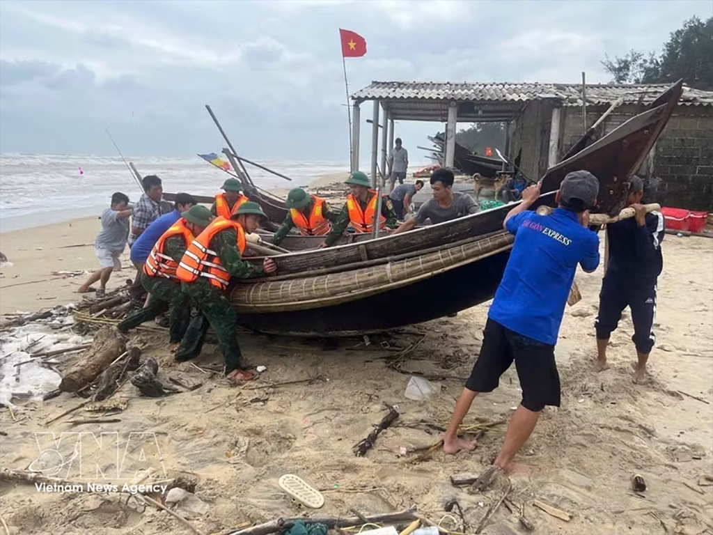Pulling a boat ashore to shelter from the storm (Photo: VNA)