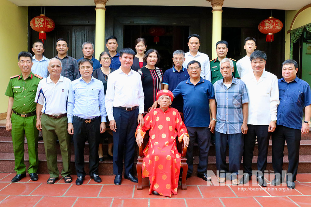 Secretary of provincial party committee Tran Huy Tuan presents gift to former revolutionist in Truong Thi ward.