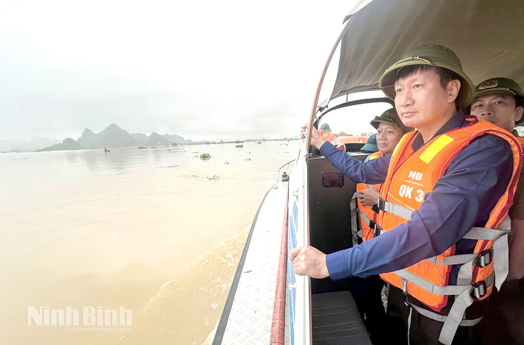 Secretary of provincial people committee Tran Huy Tuan inspects flood in Hoang Long river.