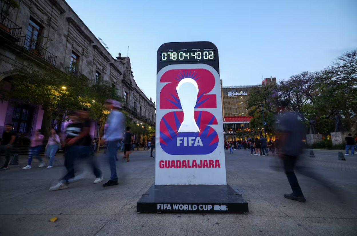 Người dân đi ngang qua đồng hồ đếm ngược cho World Cup 2026 tại Guadalajara, Mexico. Ảnh: REUTERS