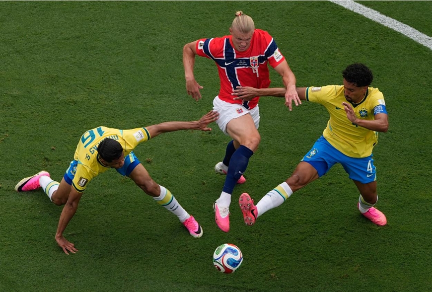 Erling Haaland tranh chấp quyết liệt giữa vòng vây của hai cầu thủ Brazil. Ảnh: AP.